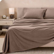 View of fleece sheets from the end of a bed with the top sheet draped over the side and end