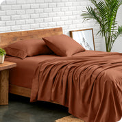 Microfiber sheets and matching pillowcases on a bed next to a large plant
