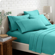 Close up of the microfiber bed sheets on a bed with four pillows.