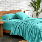 Microfiber sheets and matching pillowcases on a bed next to a large plant