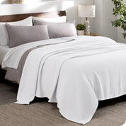 A cotton waffle blanket draped over a bed