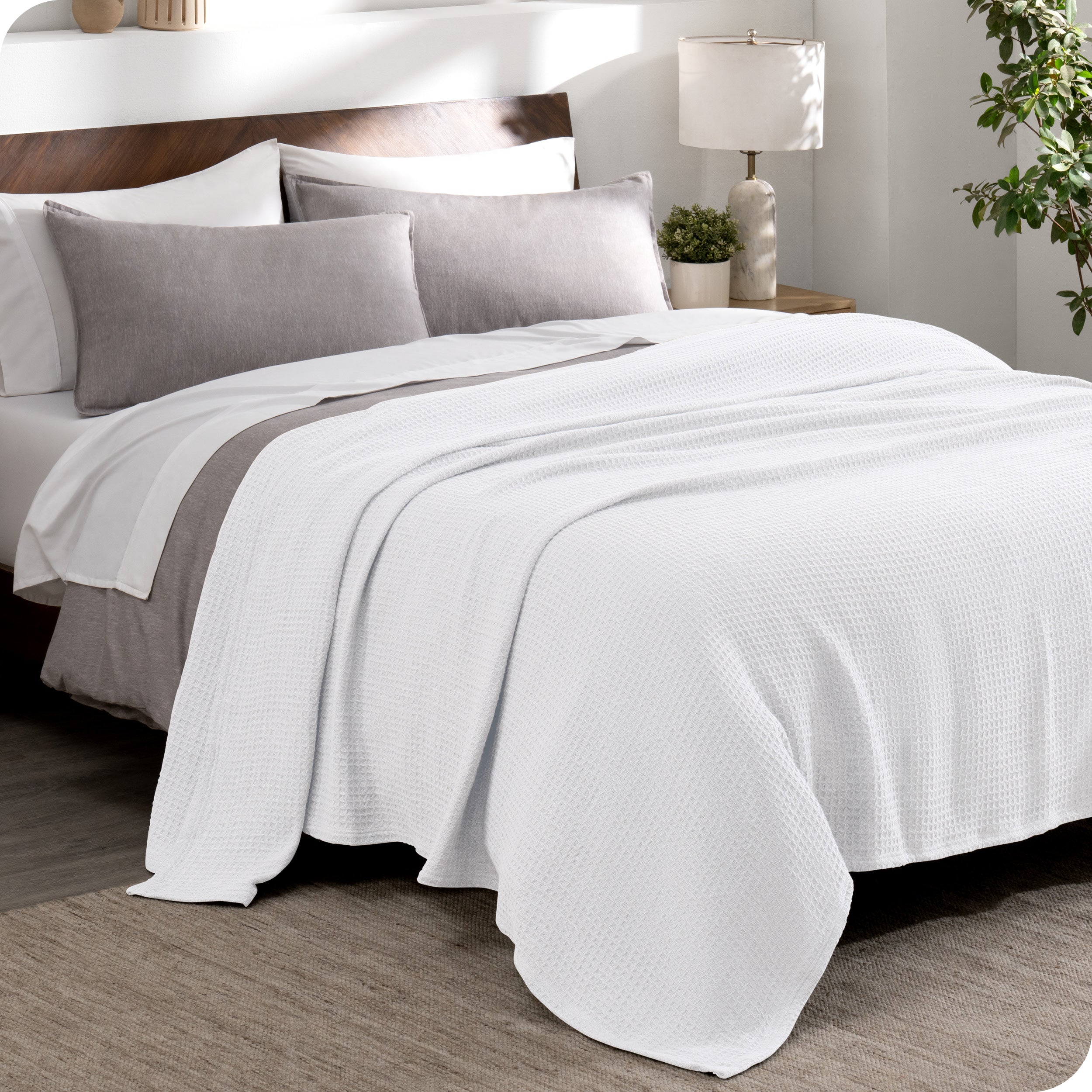 A cotton waffle blanket draped over a bed
