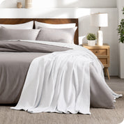 A cotton waffle blanket on the corner of a bed