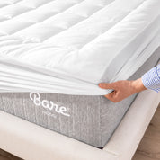 The corner of a mattress with a mattress pad putting on it