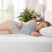 A women is sleeping on the bed with cotton mattress pad.