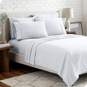 A bedroom setting with a bed made with the microfiber bed sheets and four pillows.