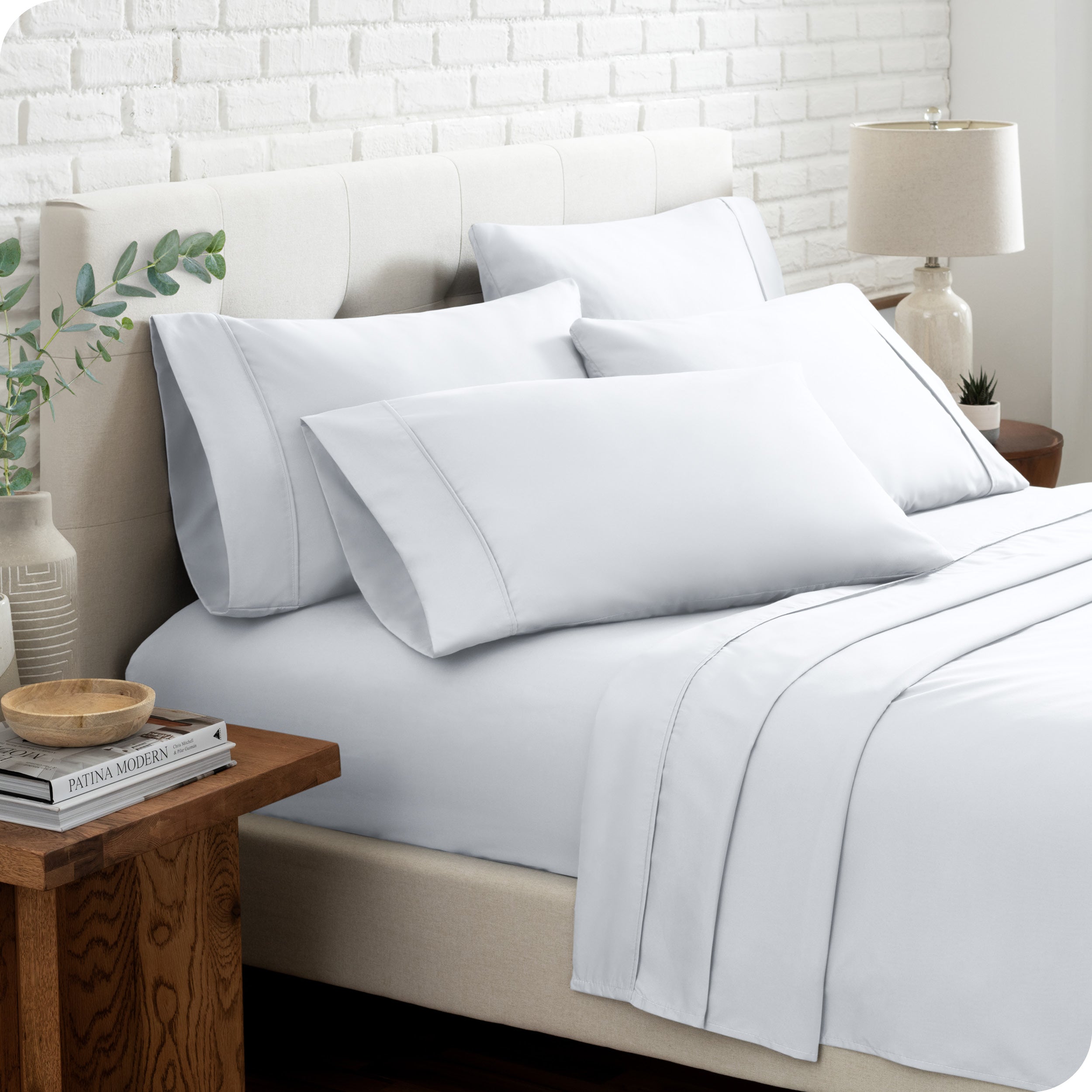 Close up of the microfiber bed sheets on a bed with four pillows.