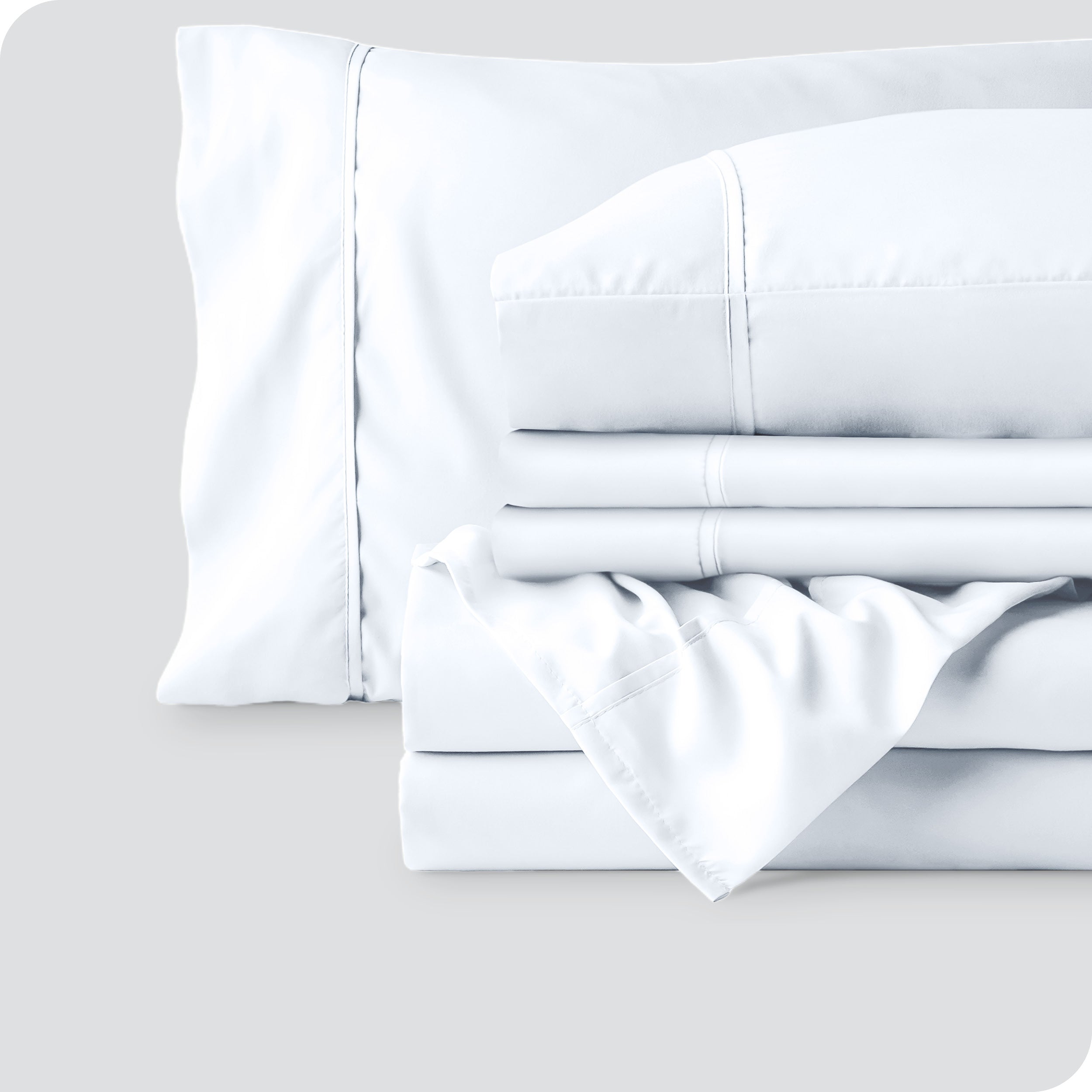 Microfiber sheets neatly folded with corner draped over, two folded pillowcases and two display pillows.