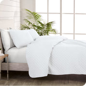 A coverlet set on a bed next to a window