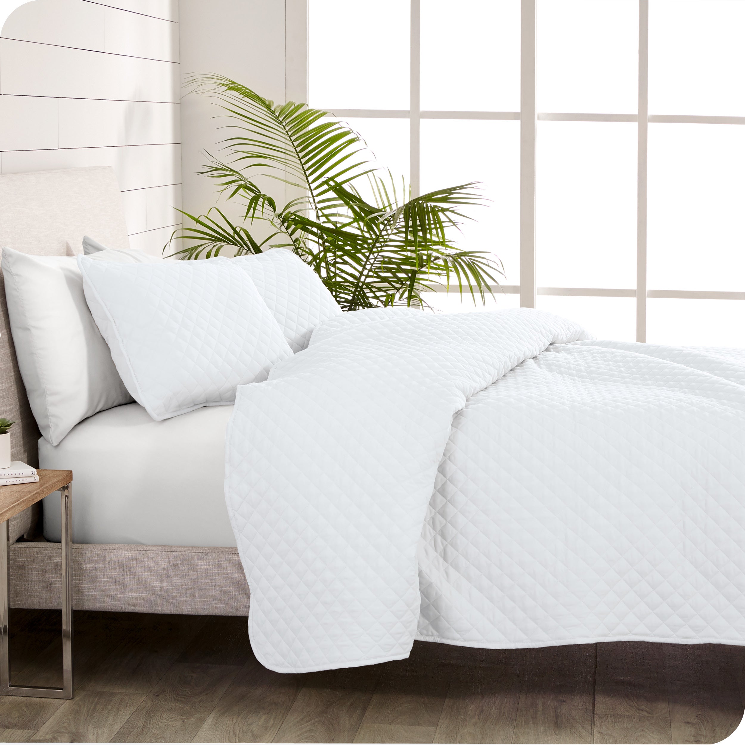 A coverlet set on a bed next to a window