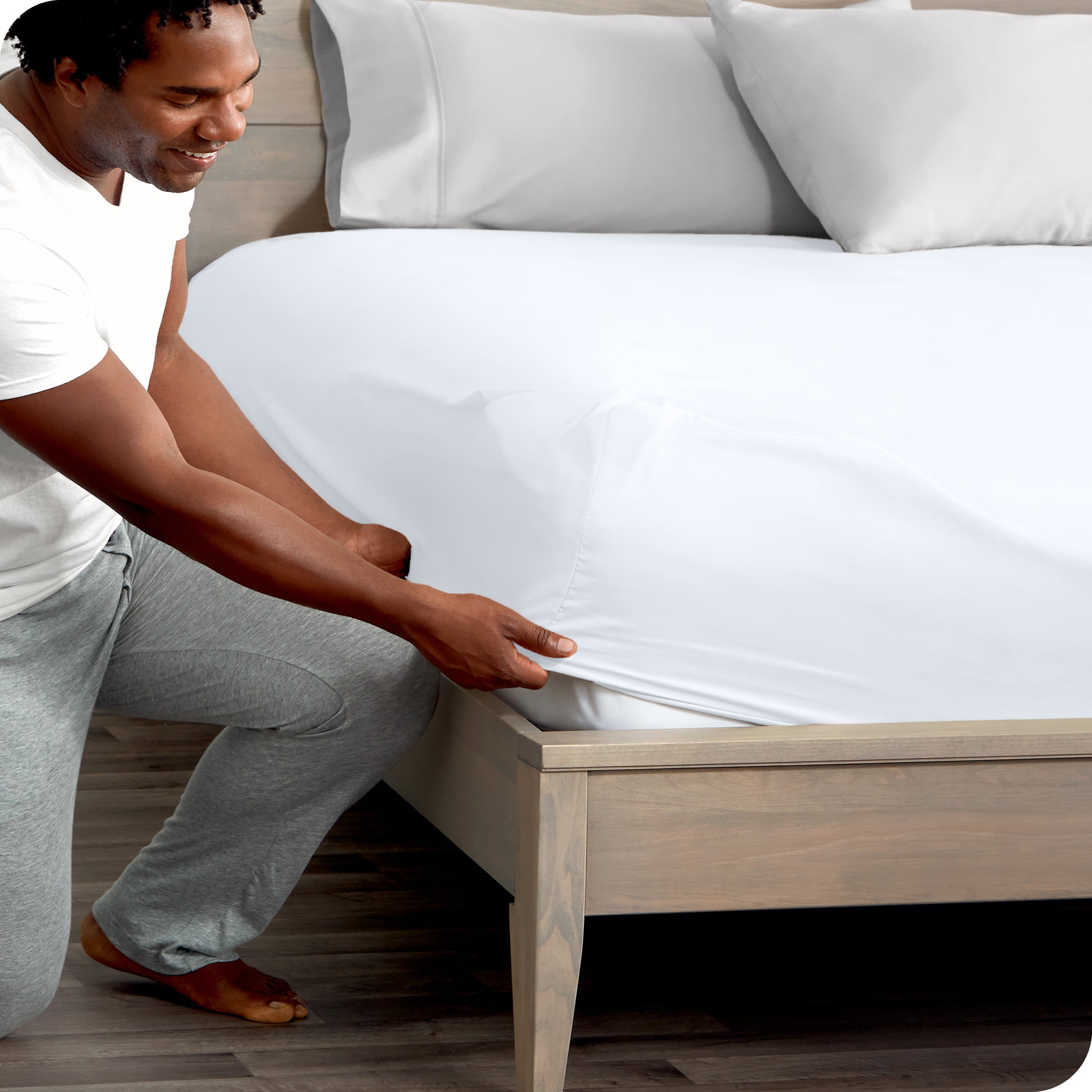 A modern bed with a fitted microfiber sheet on it