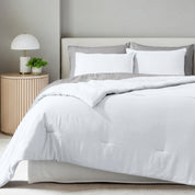 A comforter set on a bed in a bright modern room