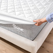 The corner of a mattress with a mattress pad putting on it