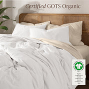 A bed made with an GOTs certified organic jersey duvet cover, pillow sham covered pillows and extra pillows