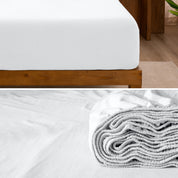 A divided image showing both the corner of a bed with organic jersey sheet and the folded sheet stacked on the bed.