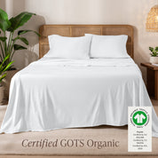 A bed in the middle of room with a set of Certified GOTS Organic Jersey Sheet Set on it.