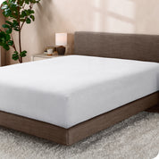 A sideview of a modern bed with a polar fleece fitted sheet on.