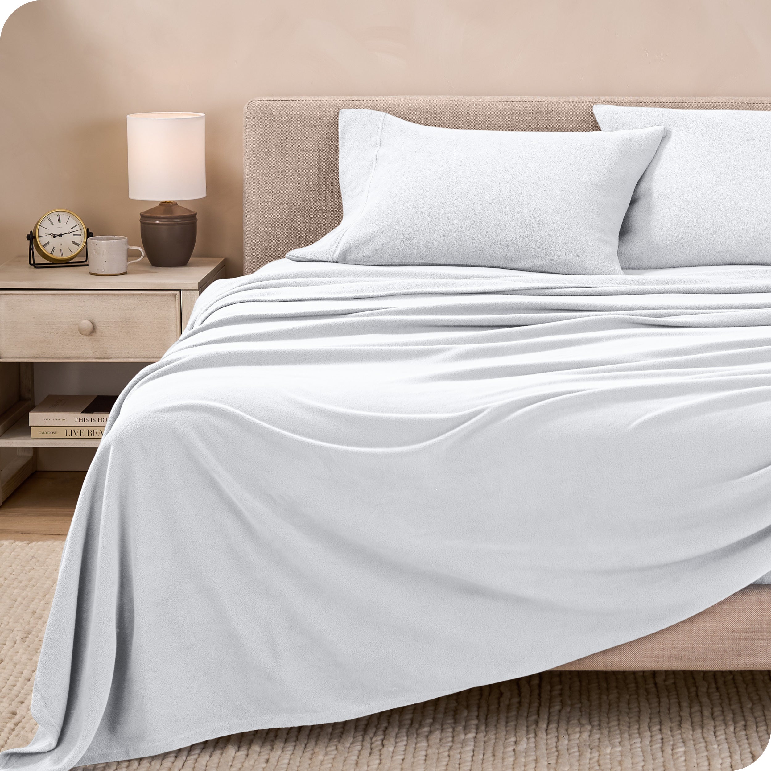View of fleece sheets from the end of a bed with the top sheet draped over the side and end