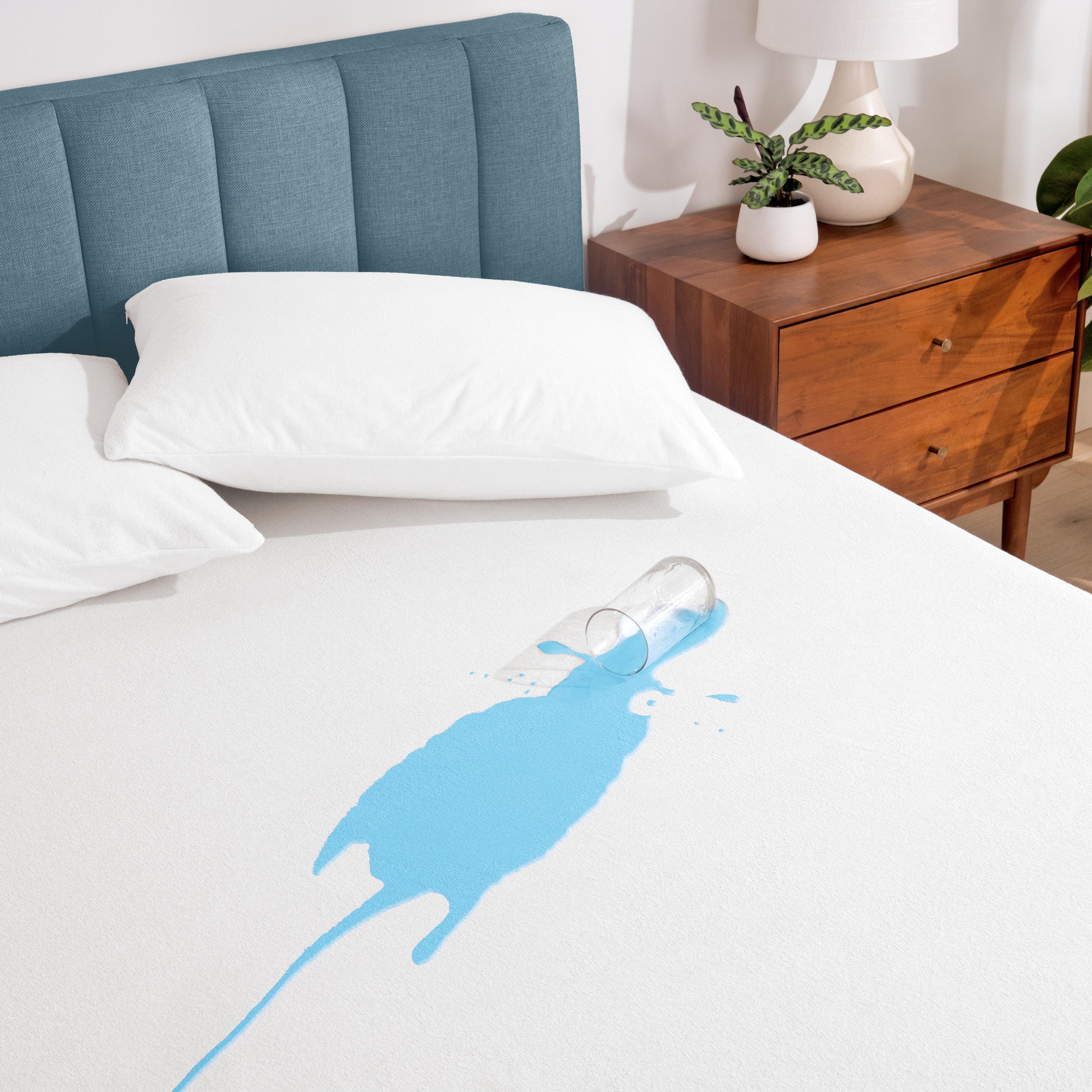 A glass of water spilled on a mattress protector