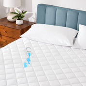 A glass of water spilled on a full size mattress protector
