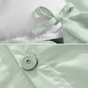 A close view of the corner tie of the duvet cover and the buttons for pillow shams