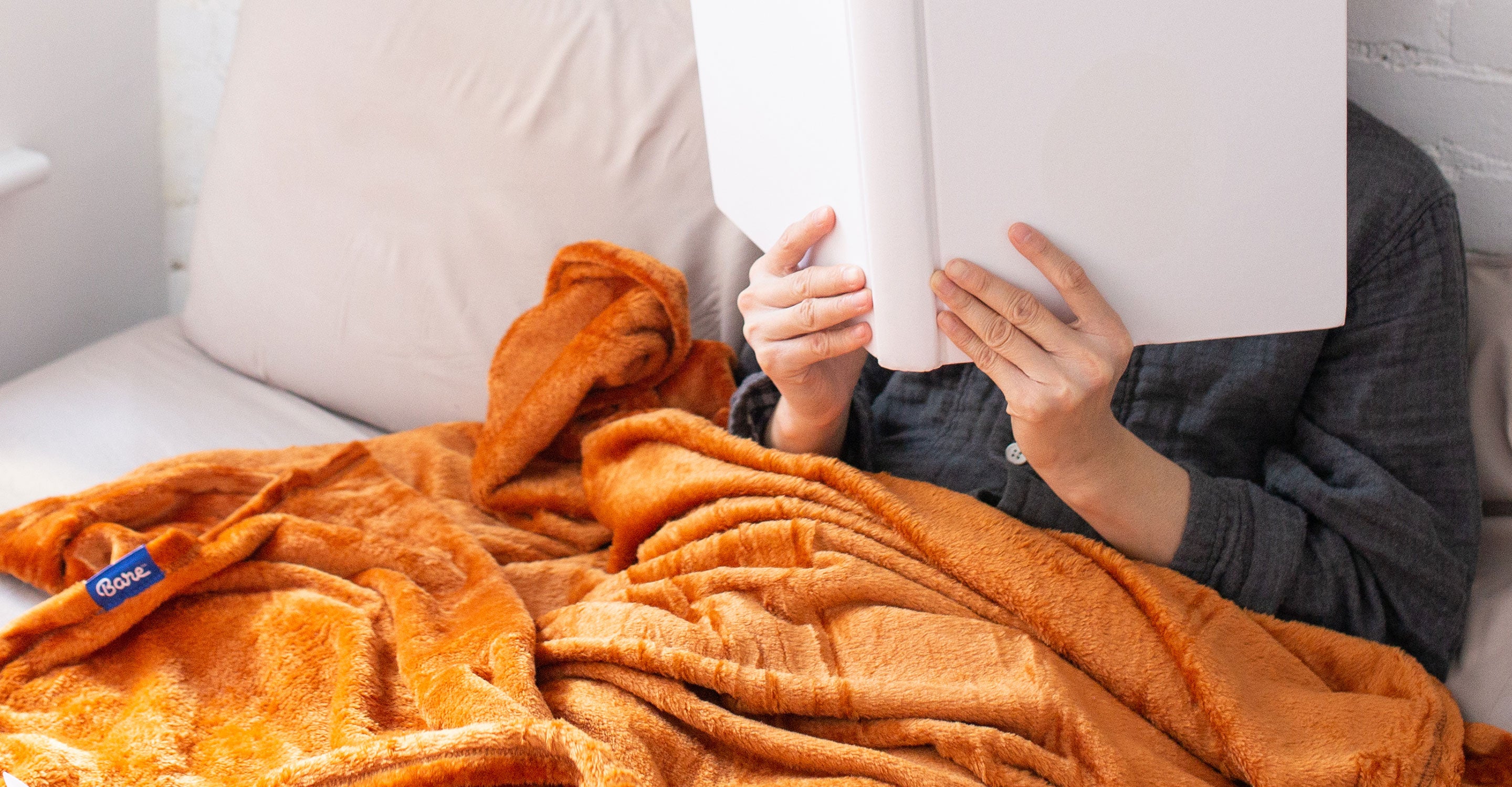 A person sitting in bed reading a book