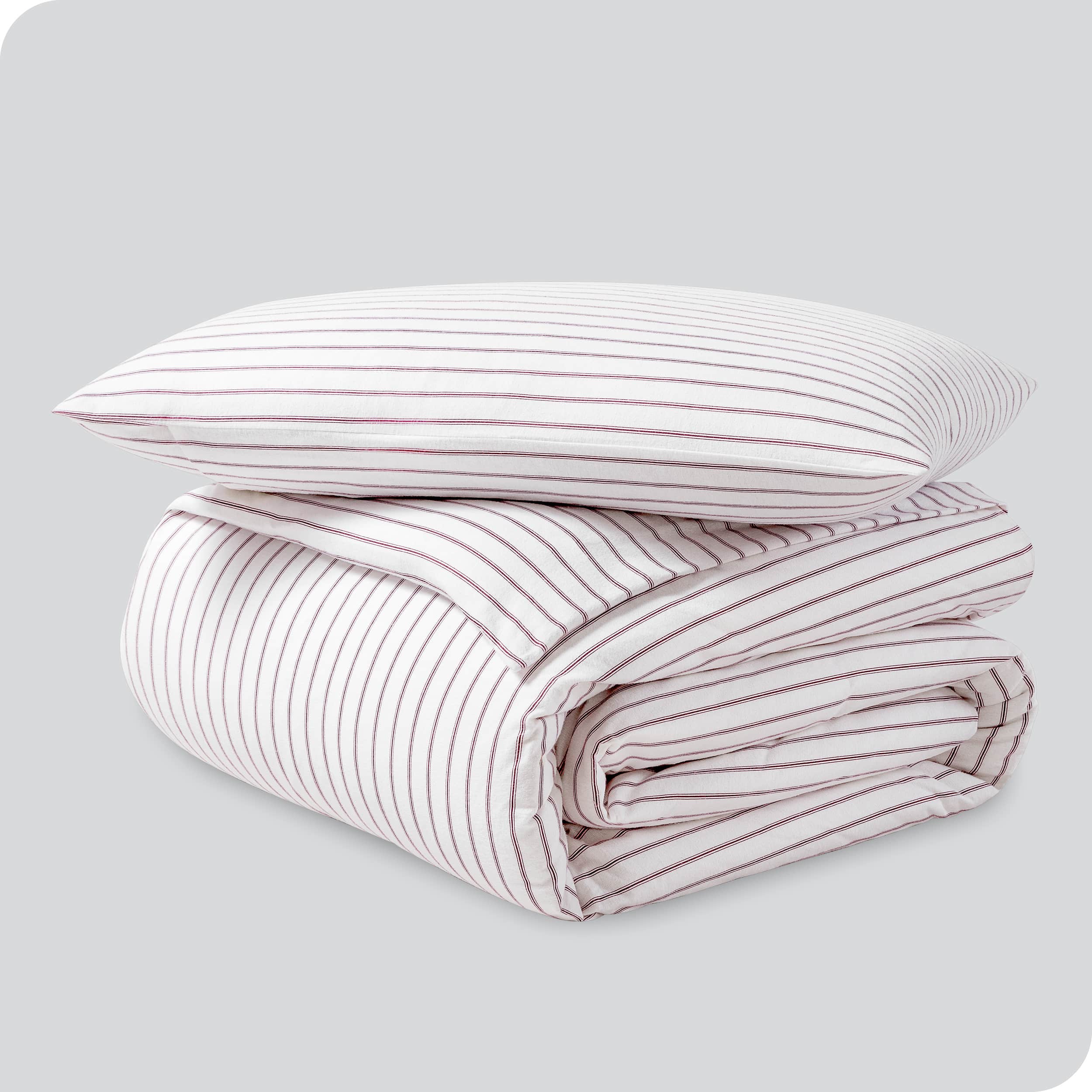 A folded stack of a printed flannel duvet cover with one pillow on top.