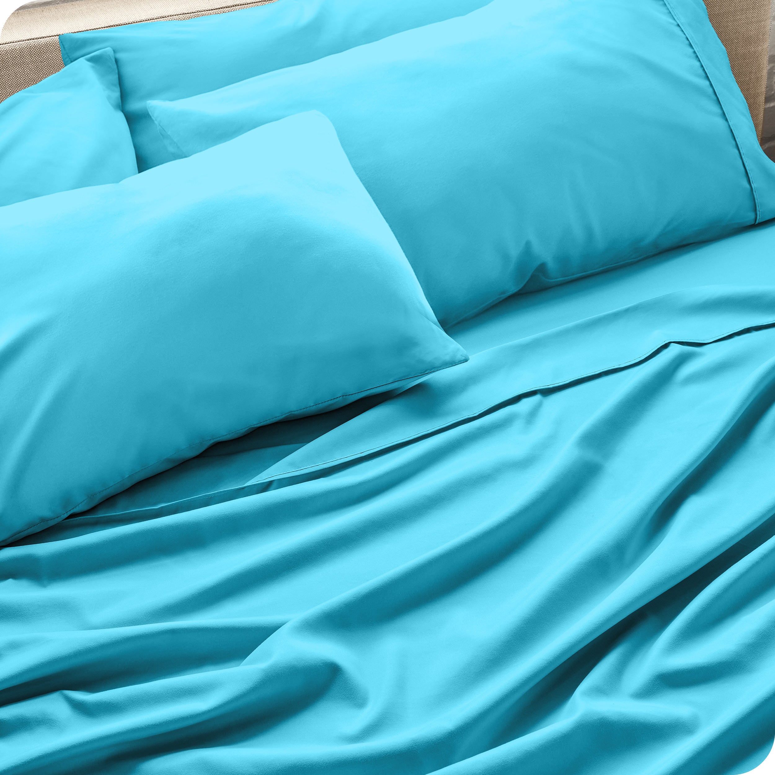 Close up of the microfiber bed sheets on a bed with four pillows.