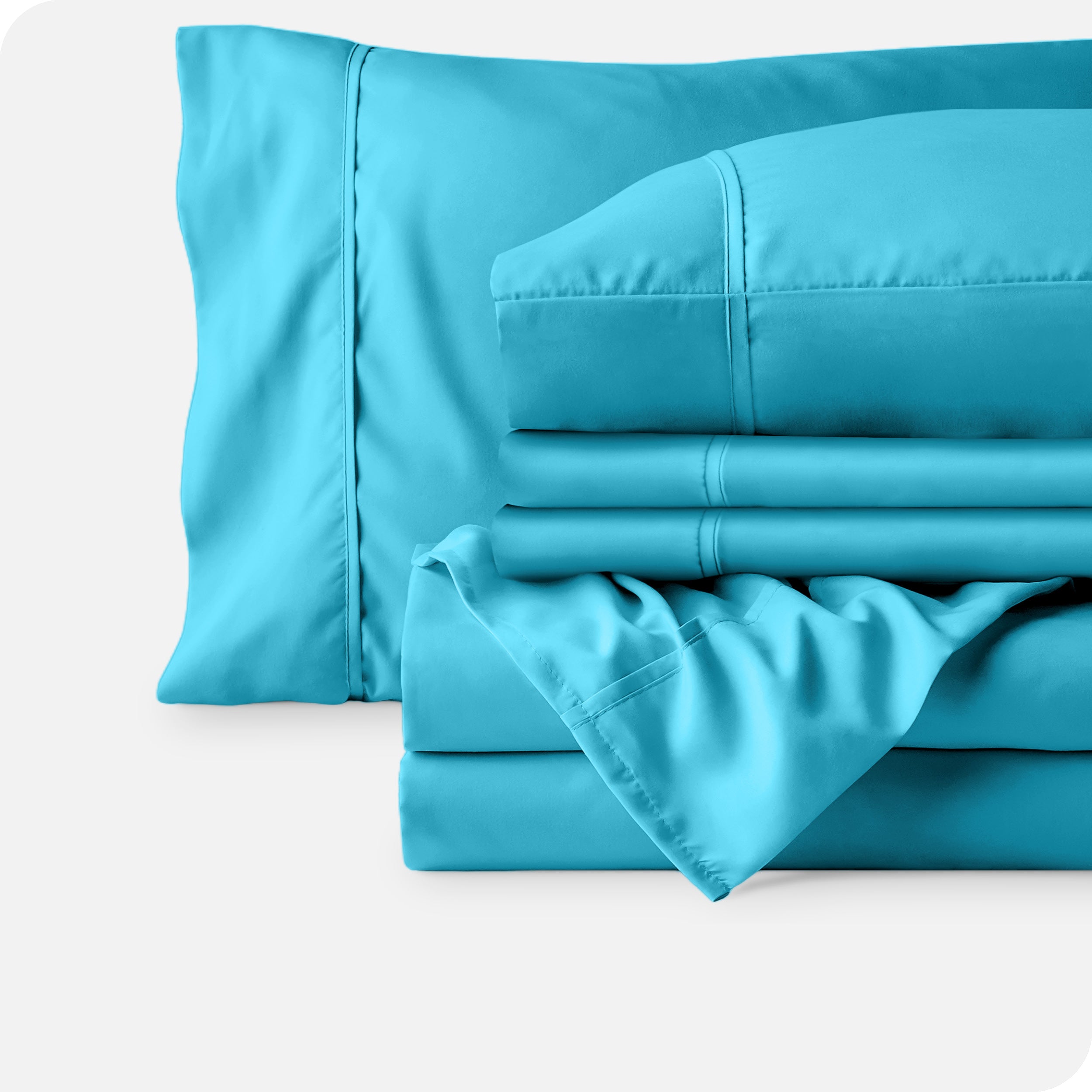 Microfiber sheets neatly folded with corner draped over, two folded pillowcases and two display pillows.