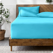 A modern bed with a fitted microfiber sheet made on the mattress. 