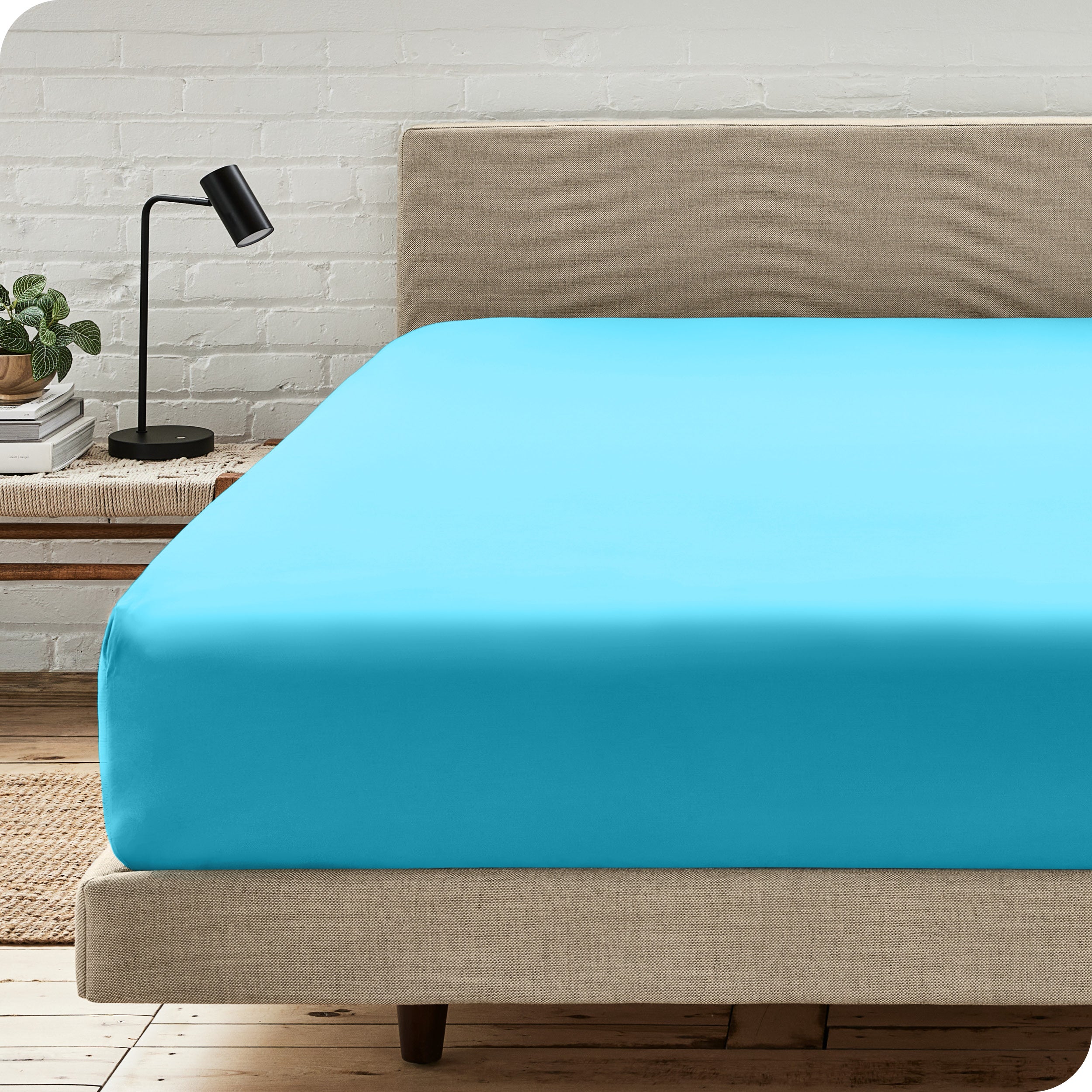 A bed with a microfiber fitted sheet on the mattress. 