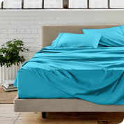 Microfiber sheets on a bed with a brick wall behind it