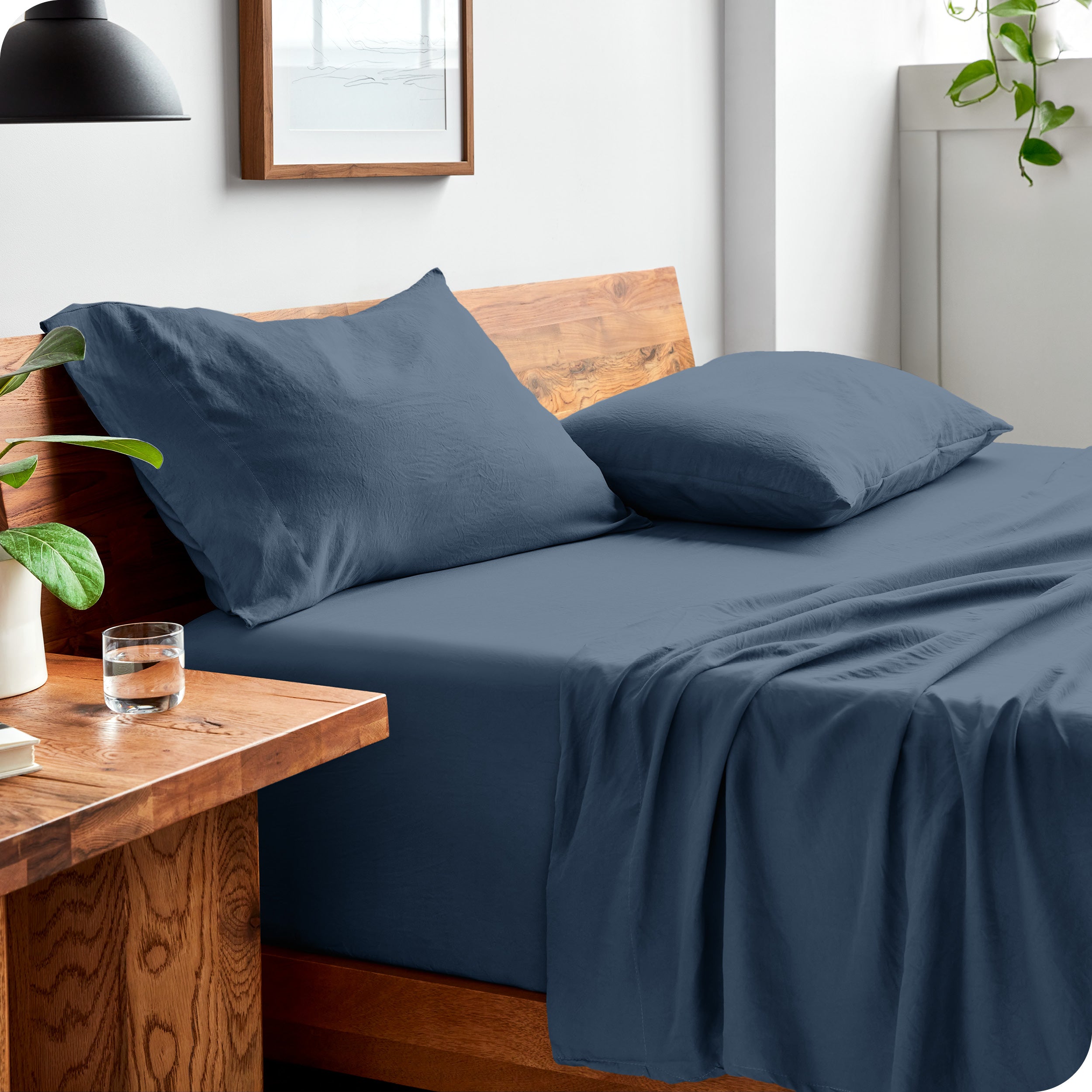 Side view of bed made with fitted sheet, pillowcases, and top sheet