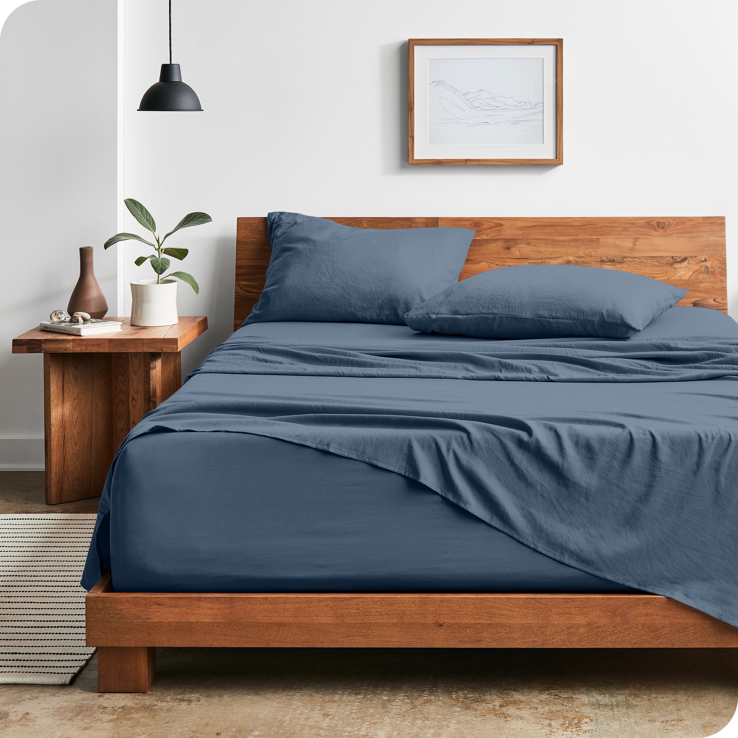 Modern bedroom with Sandwashed sheets draped over the end and side of mattress
