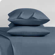 Two sateen pillowcases stacked on a bed
