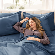 A woman sleeping on a bed made with organic cotton sateen sheets and pillowcases