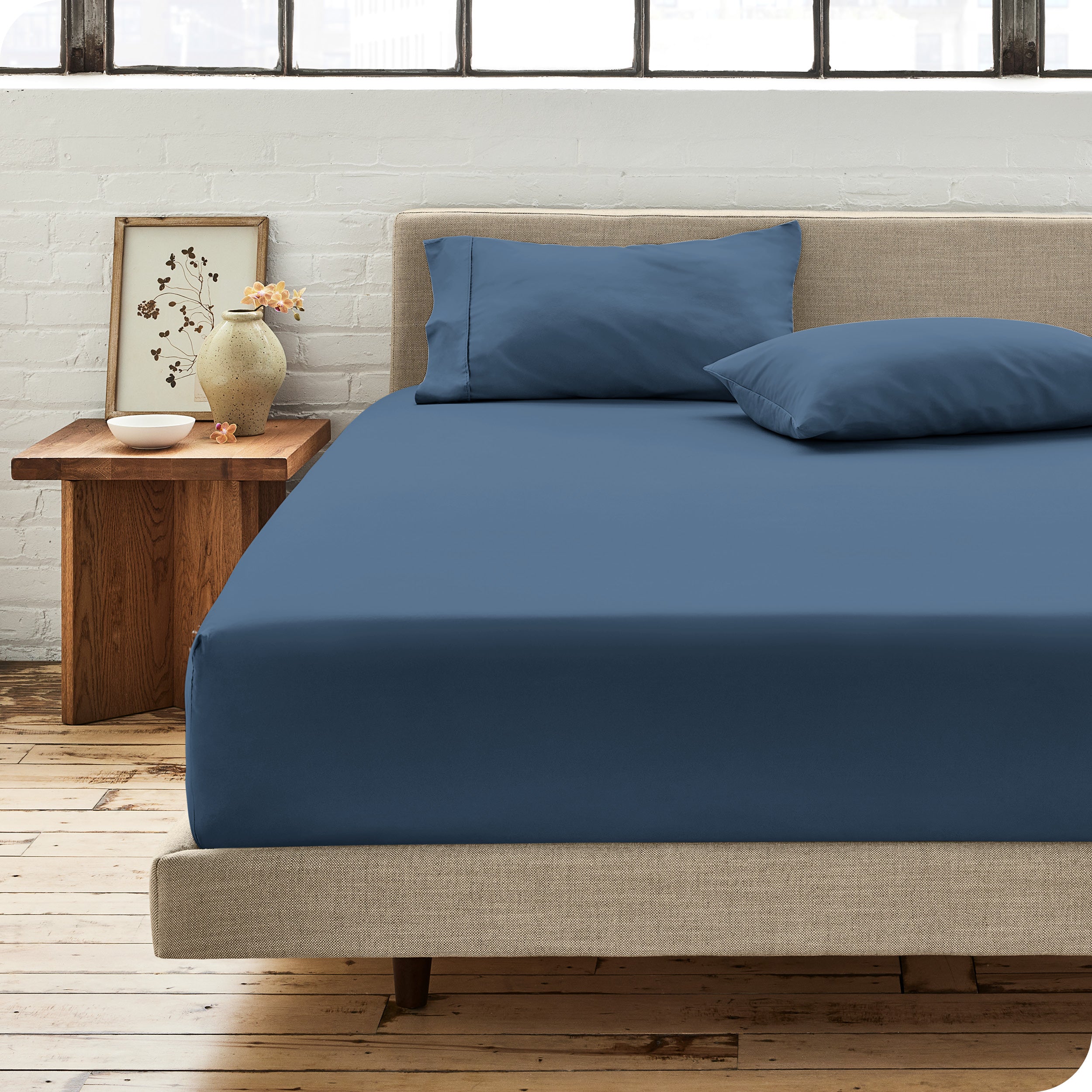 Percale fitted sheet on a mattress with matching pillowcases on pillows