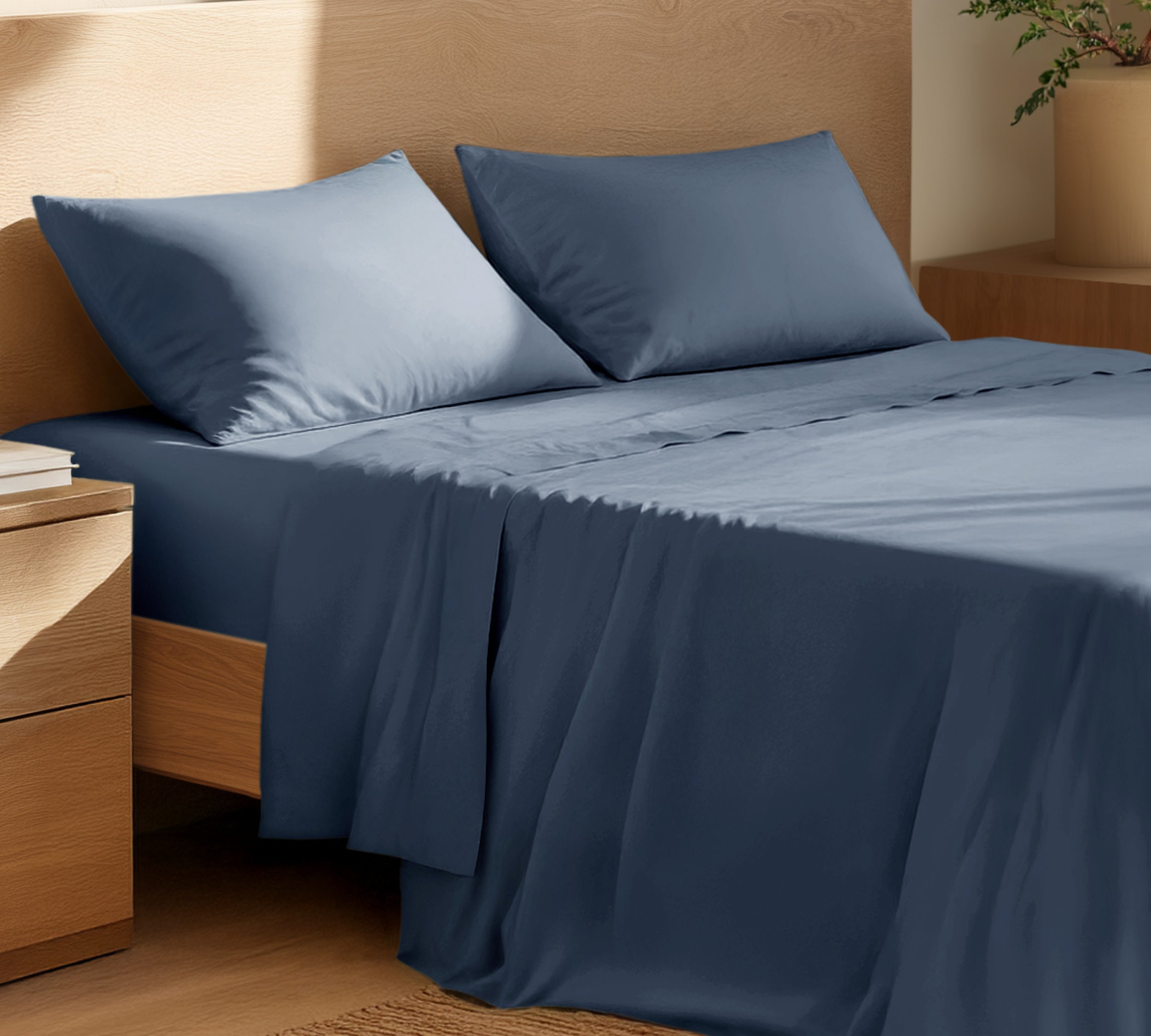 Organic cotton percale sheet set on a bed, with a flat sheet, fitted sheet, and two pillowcases displayed.