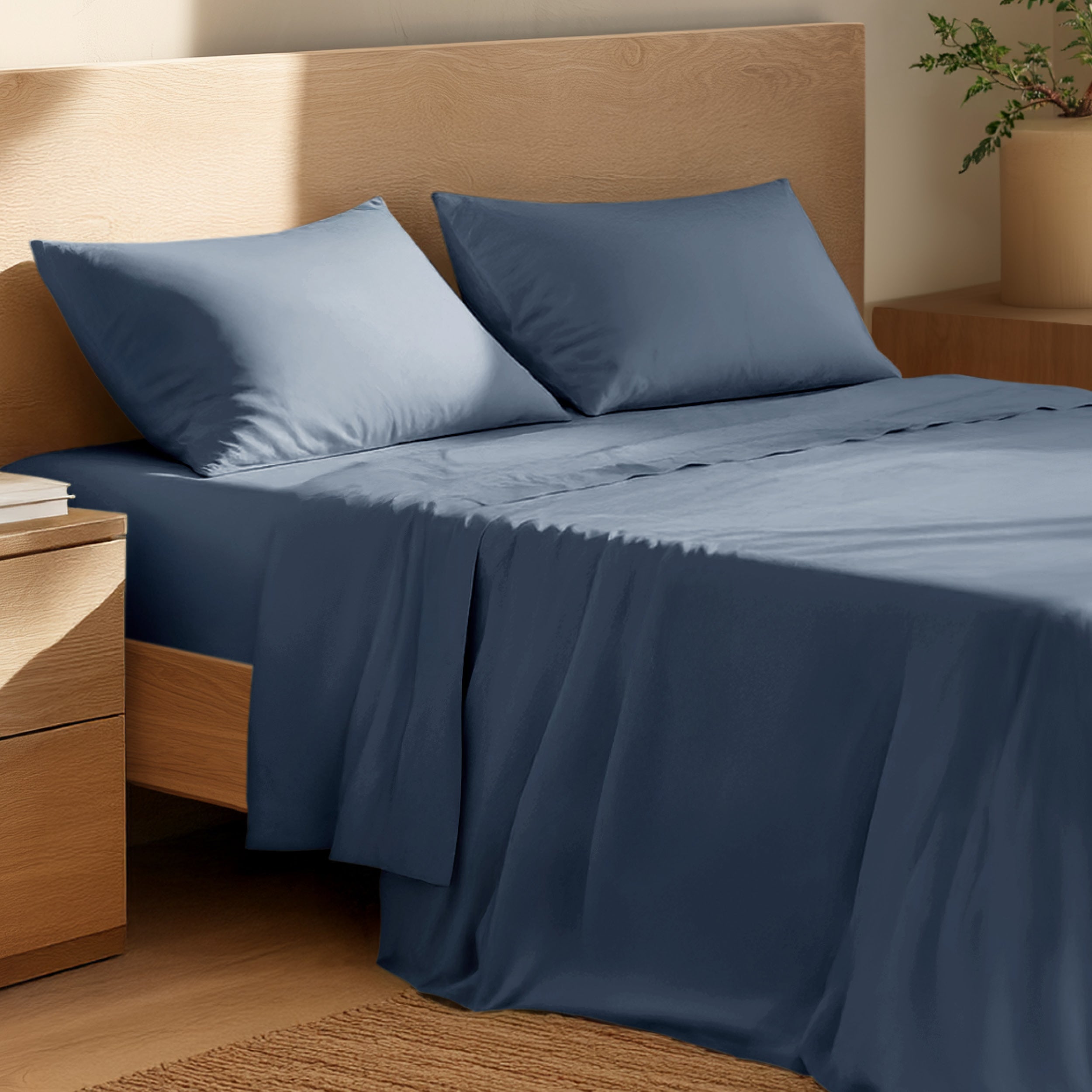 Organic cotton percale sheet set on a bed, with a flat sheet, fitted sheet, and two pillowcases displayed.