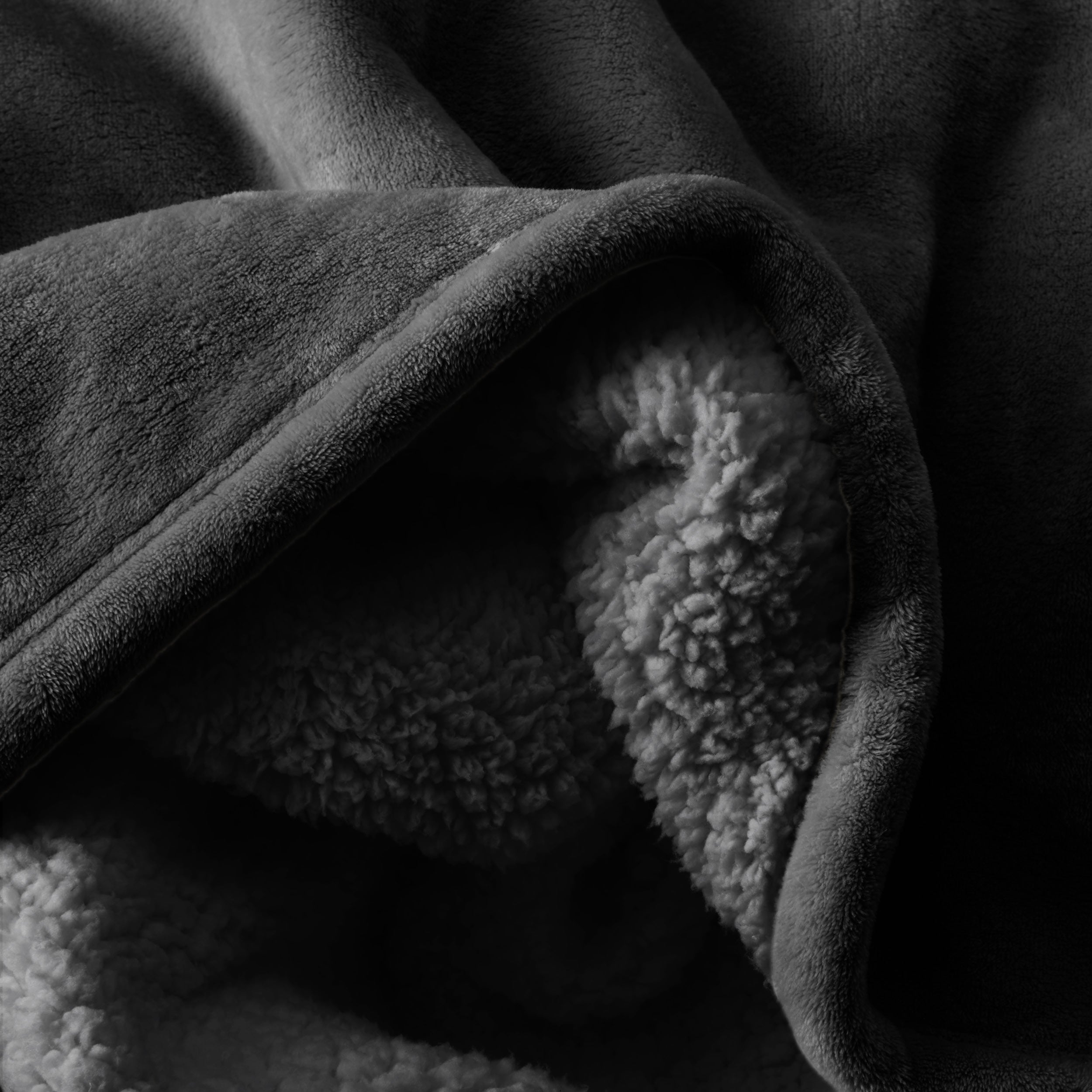 Close up of sherpa blanket showing texture of velvety soft side and sherpa backing