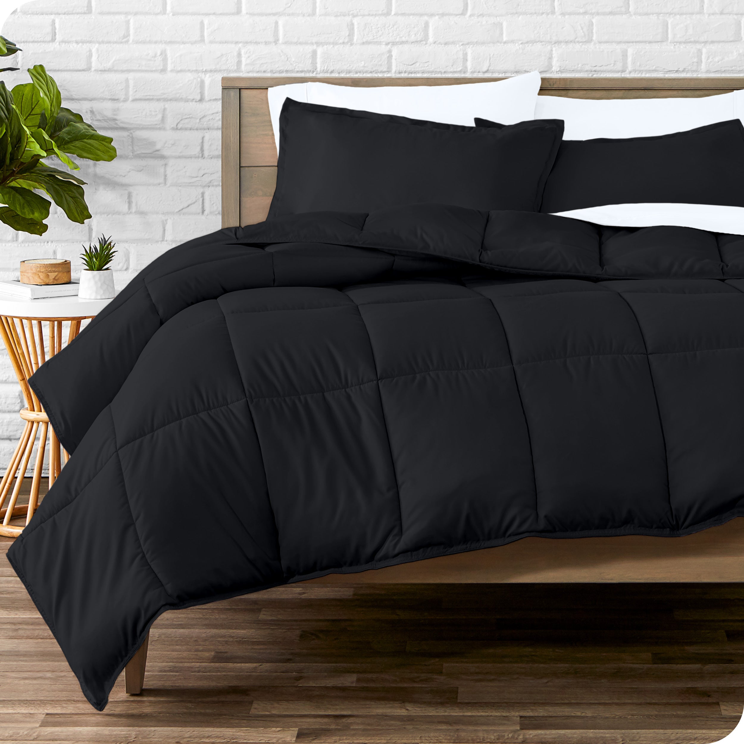 A wooden bed frame with sheets, pillow shams and a comforter on the bed