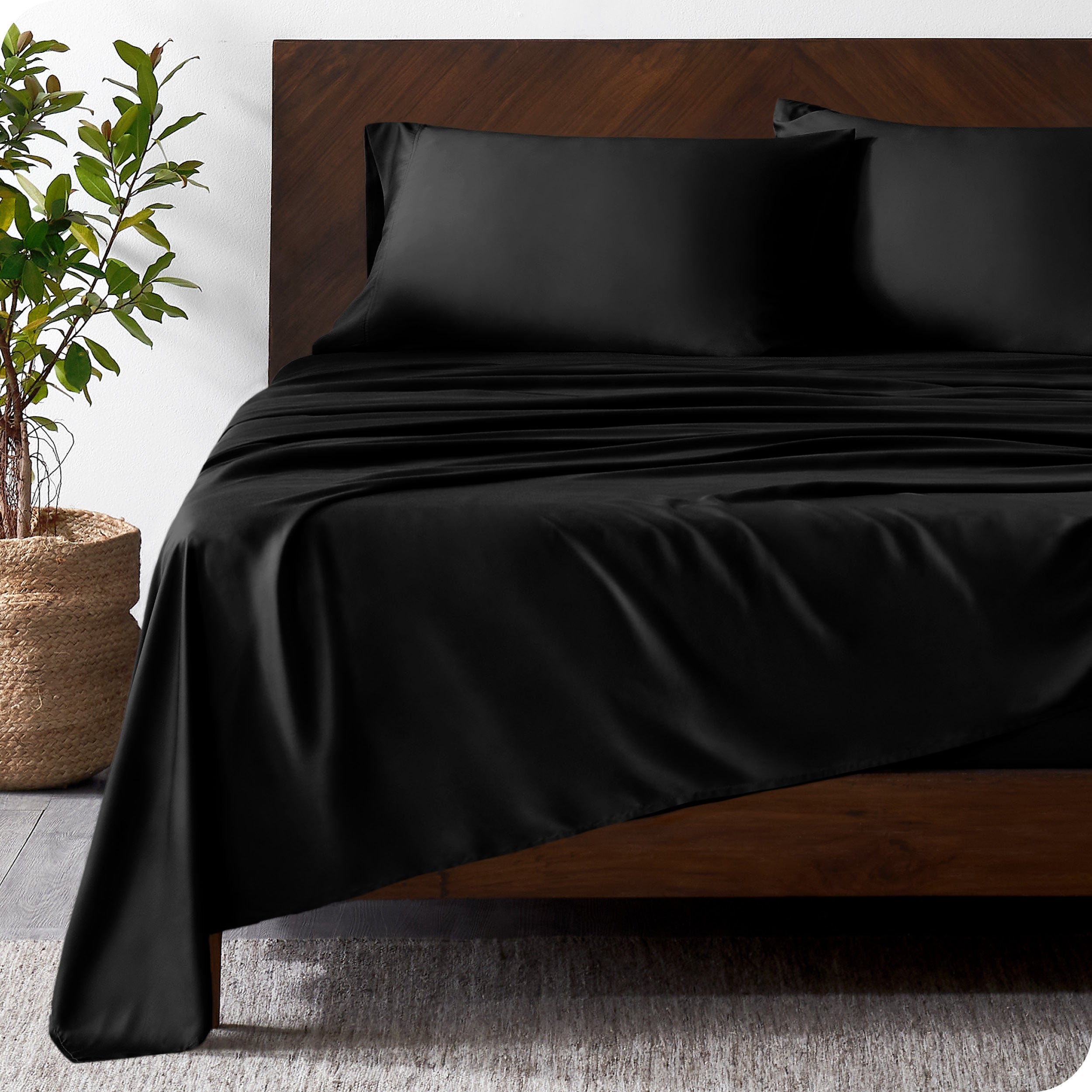 Wooden bed frame with bamboo sheets on the bed
