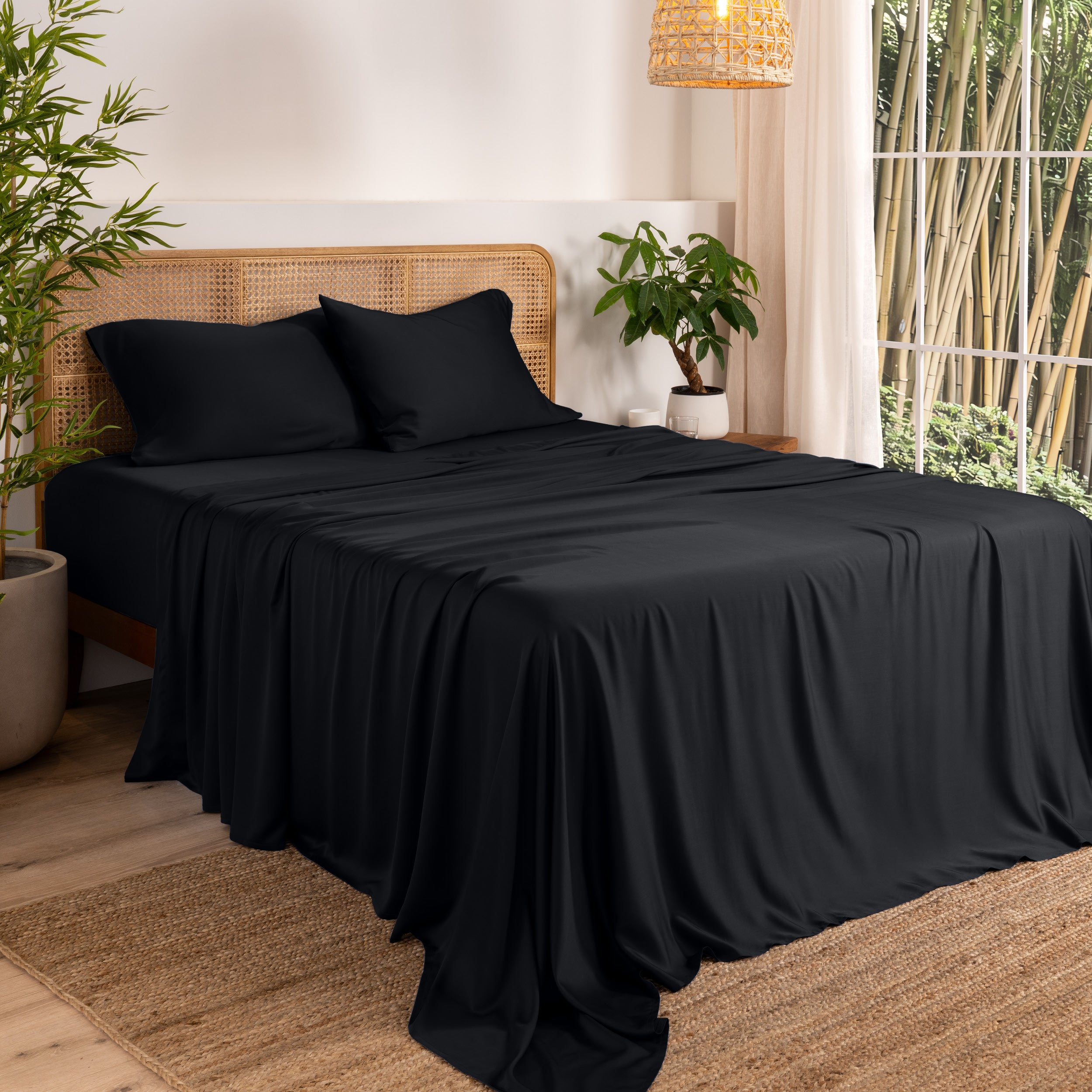 Bamboo sheets on a bed in a bedroom with plants and a window.