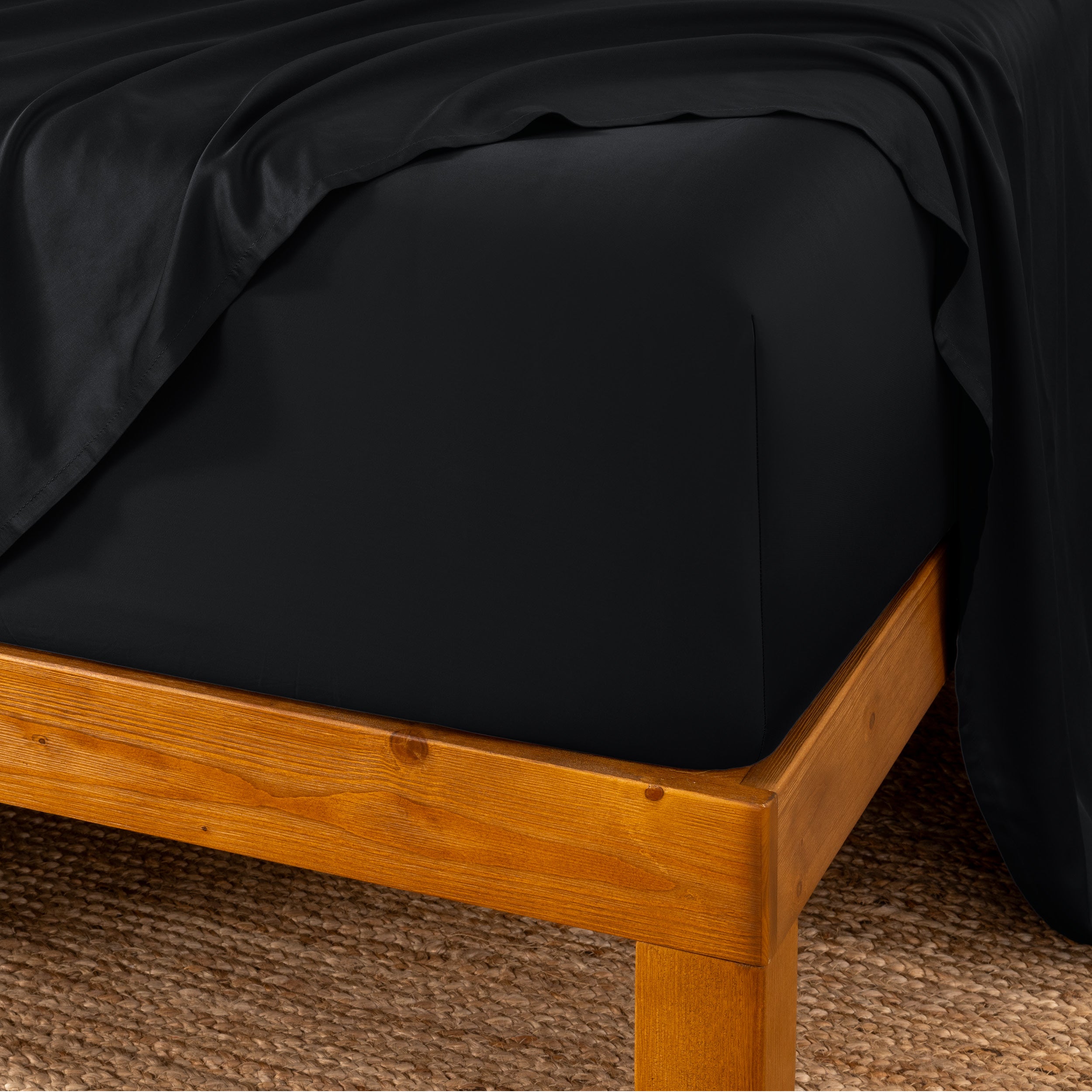 Bed sheets on a wooden bed frame with a brown carpet background