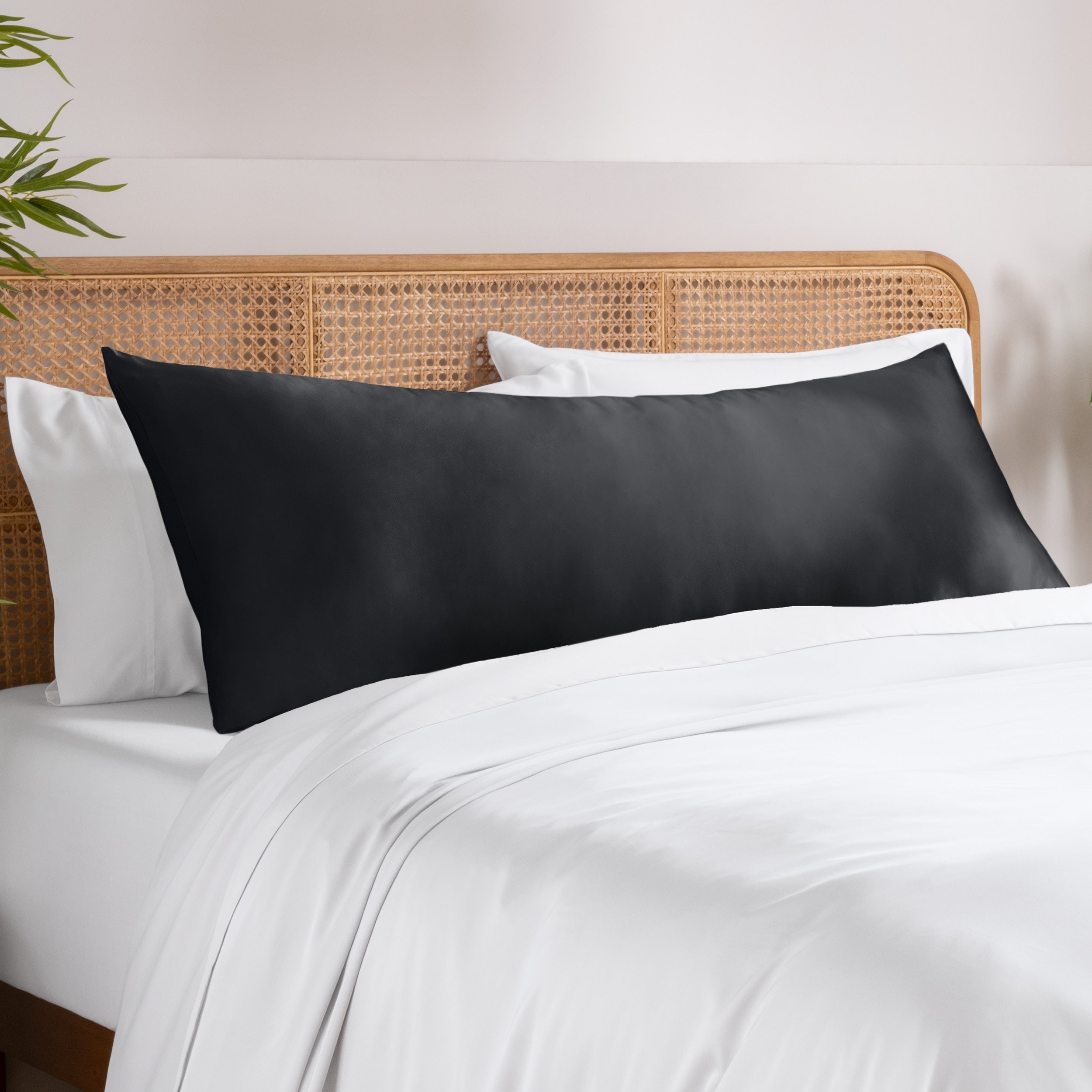 Bamboo pillowcase on a bed with white bedding and a wooden headboard.