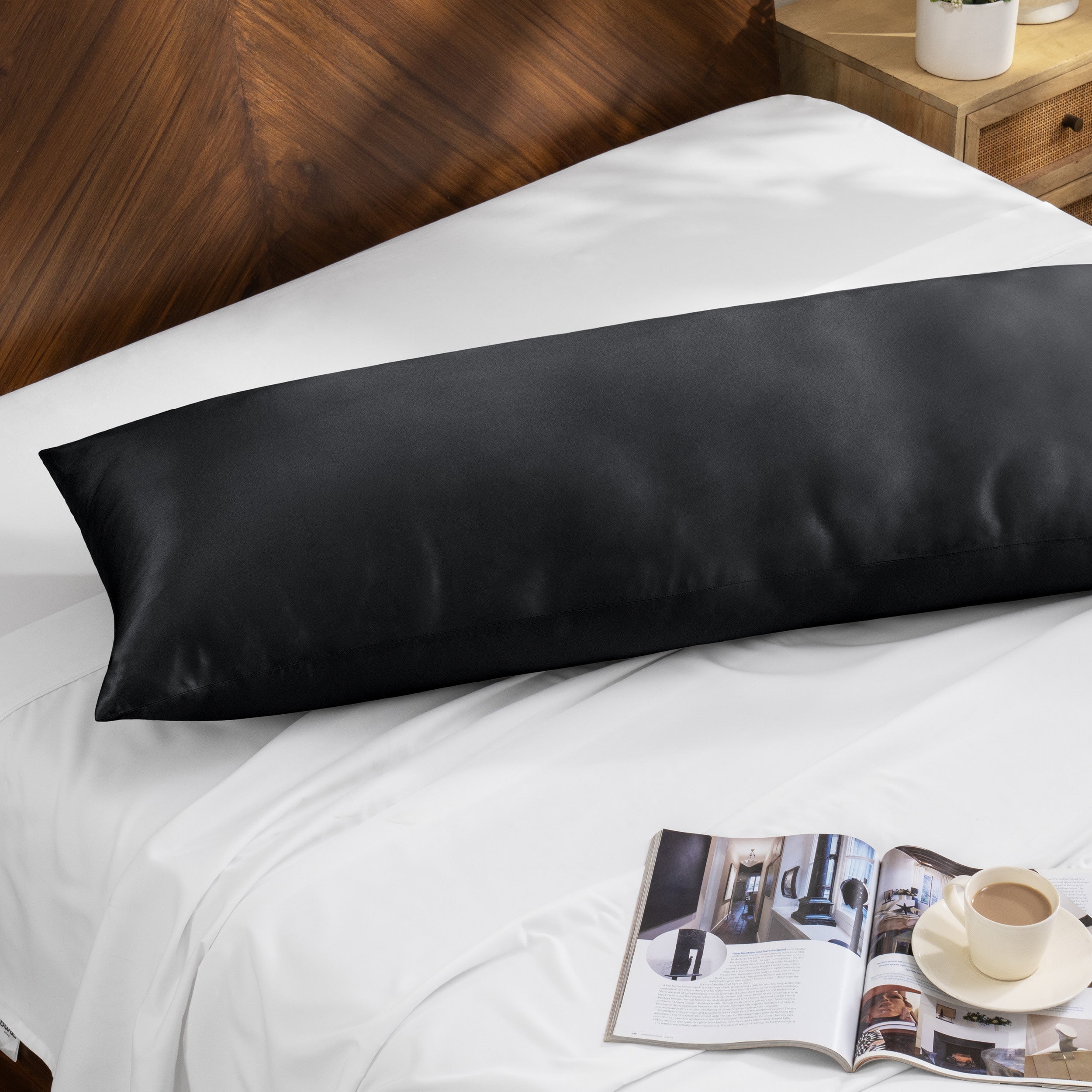 Bamboo body pillow on a bed with a magazine and cup of coffee nearby.