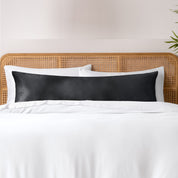 Bamboo body pillowcase on a bed with white bedding and a wicker headboard.
