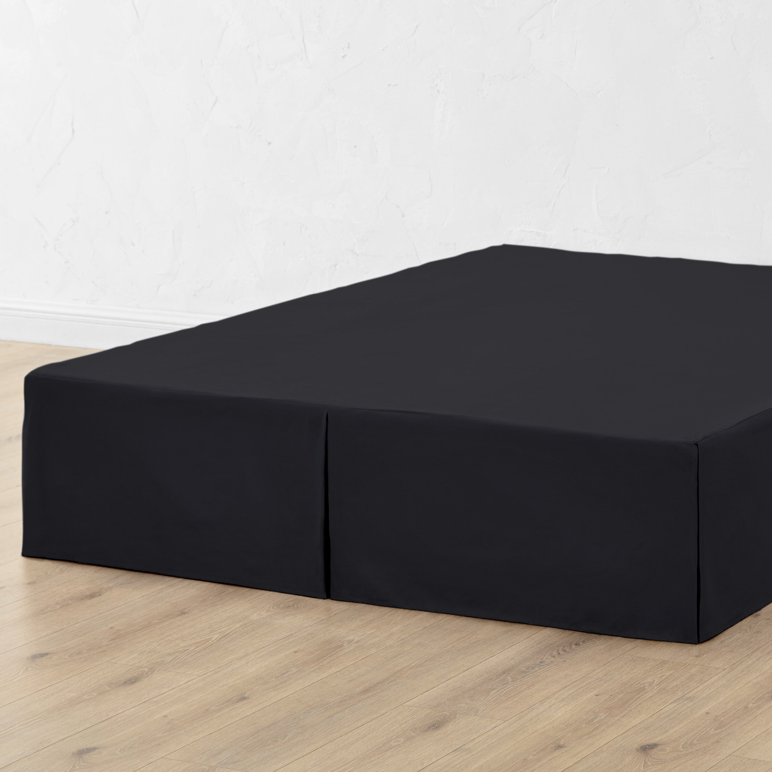 A bed skirt draped over a box spring