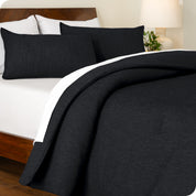 A side view of a modern bed with a comforter set and pillow shams on the bed
