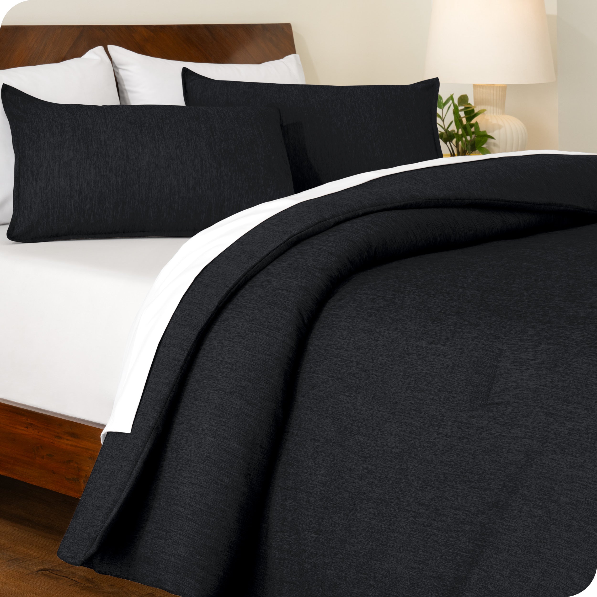 A side view of a modern bed with a comforter set and pillow shams on the bed
